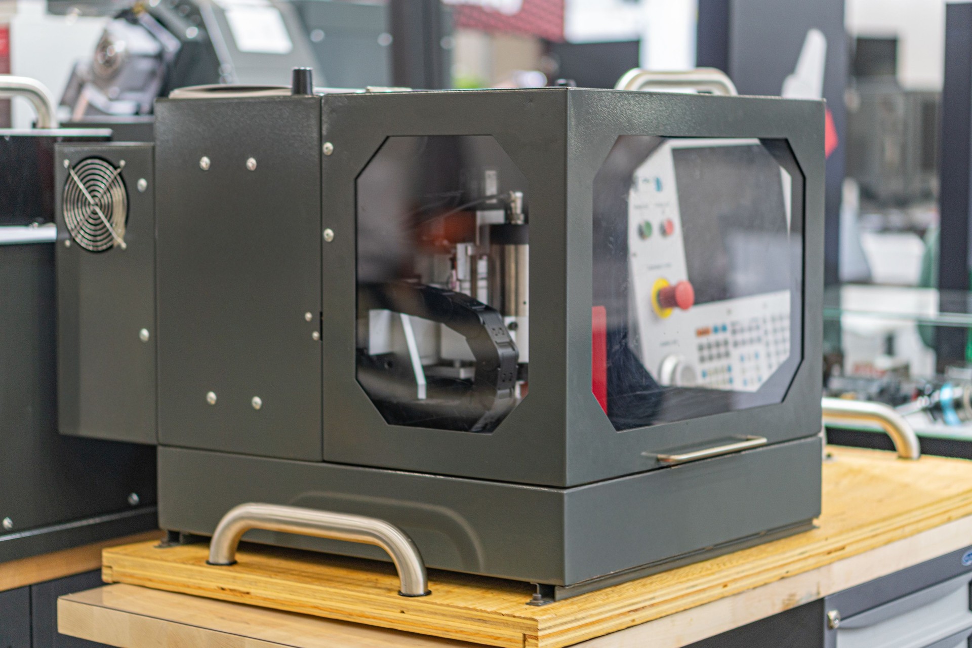 Industrial setting with a large CNC router or cutting device, grey and blue color palette, even lighting, slightly elevated camera angle